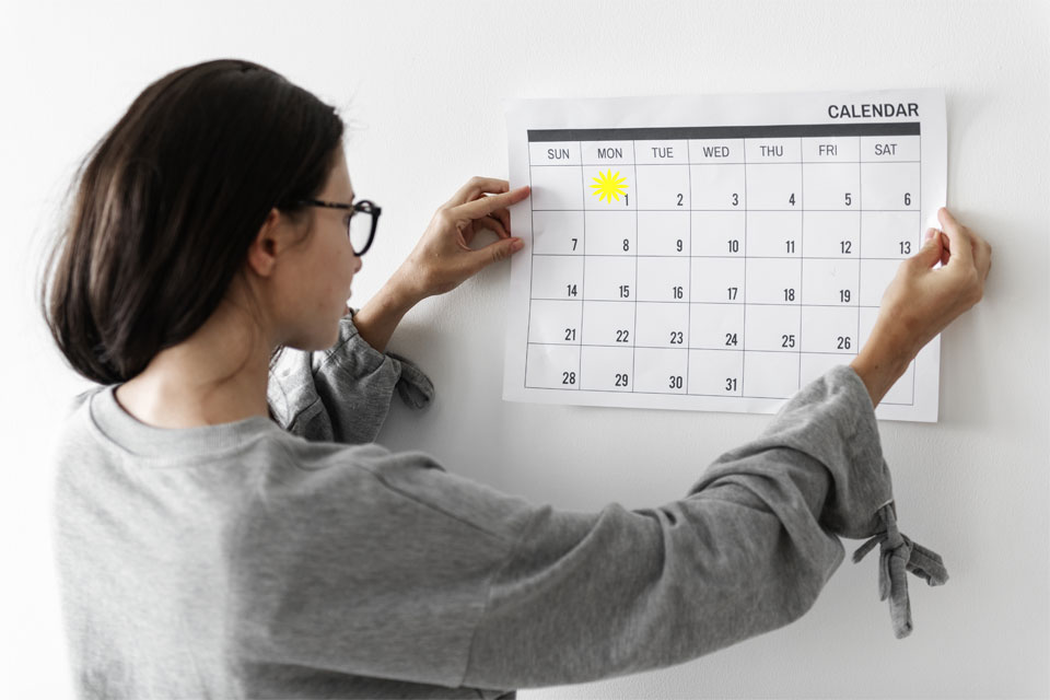 In the calendar this woman is looking at, the 1st is highlighted - is she thinking about new resolutions for her business?