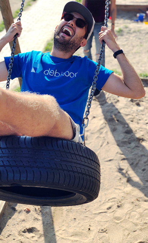 A photo of a Debitoor employee lauging on a swing