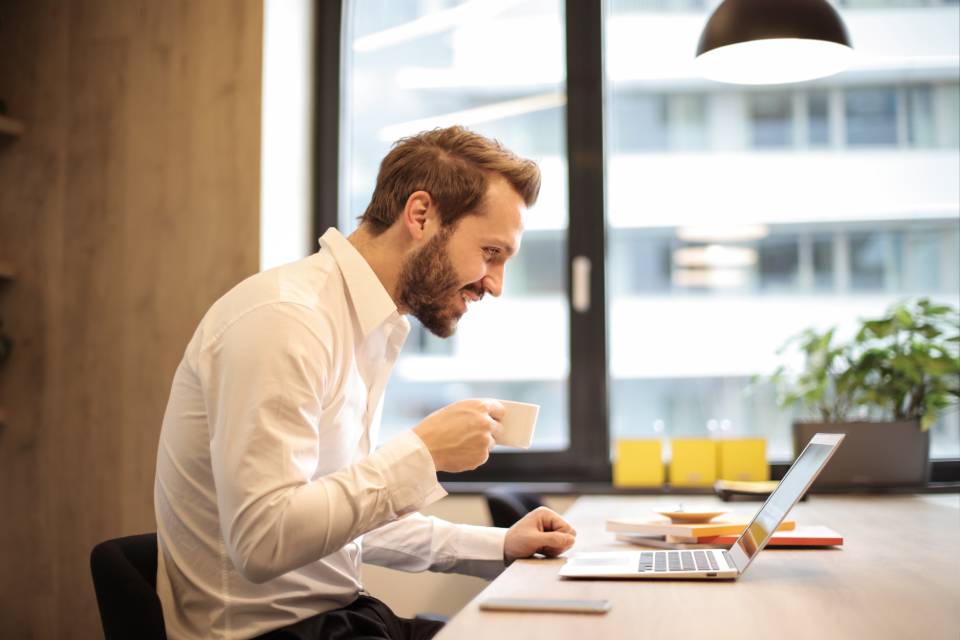 Debitoor is always working to make our users' lives easier, to make them as happy as this smiling man at a computer