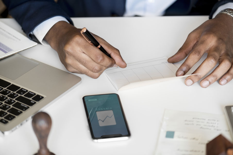 A man balancing his chequebook. Reconciliation can be easier with Debitoor invoicing software