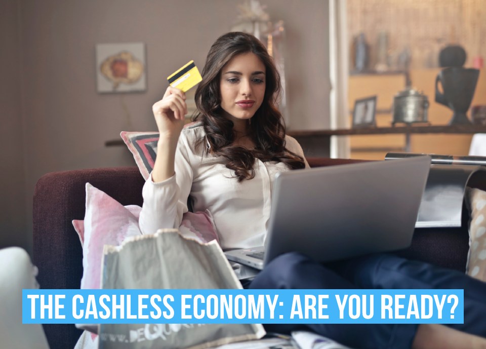 A women holiday a credit card and text saying 'Cashless economy, are you ready?"