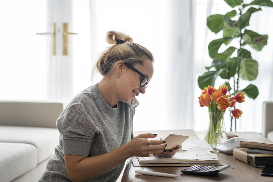 Managing expenses can be easy for this woman sitting at the desk in her home office, thanks to accounting & invoicing software