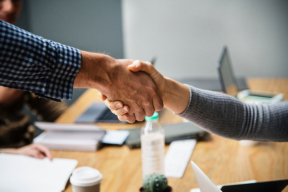 Image of people shaking hands at the end of a deal.