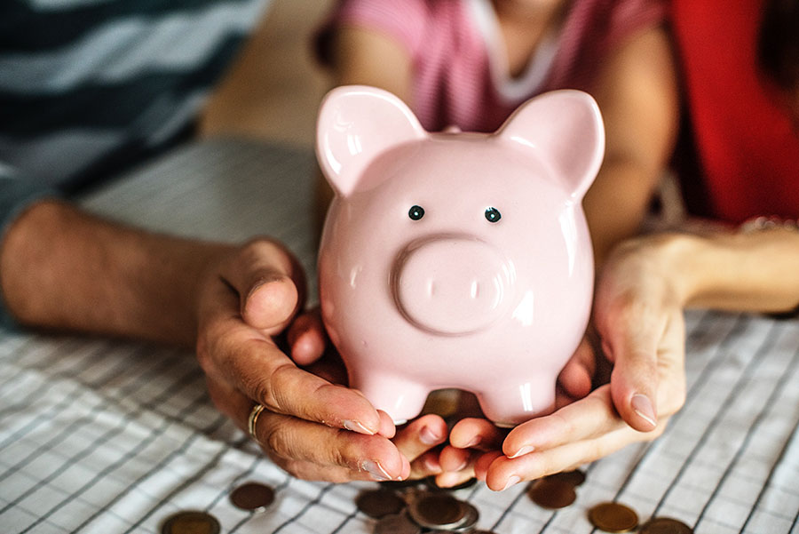 Image of parents and childing holding a piggy bank. Make the most of your savings with an Individual Savings Account