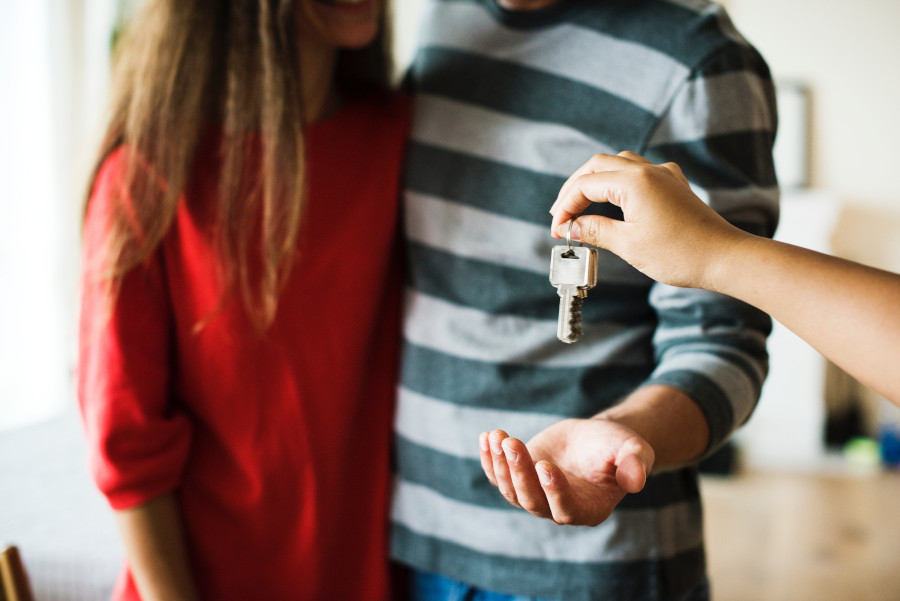 picture of couple being handed keys to house by real estate agent