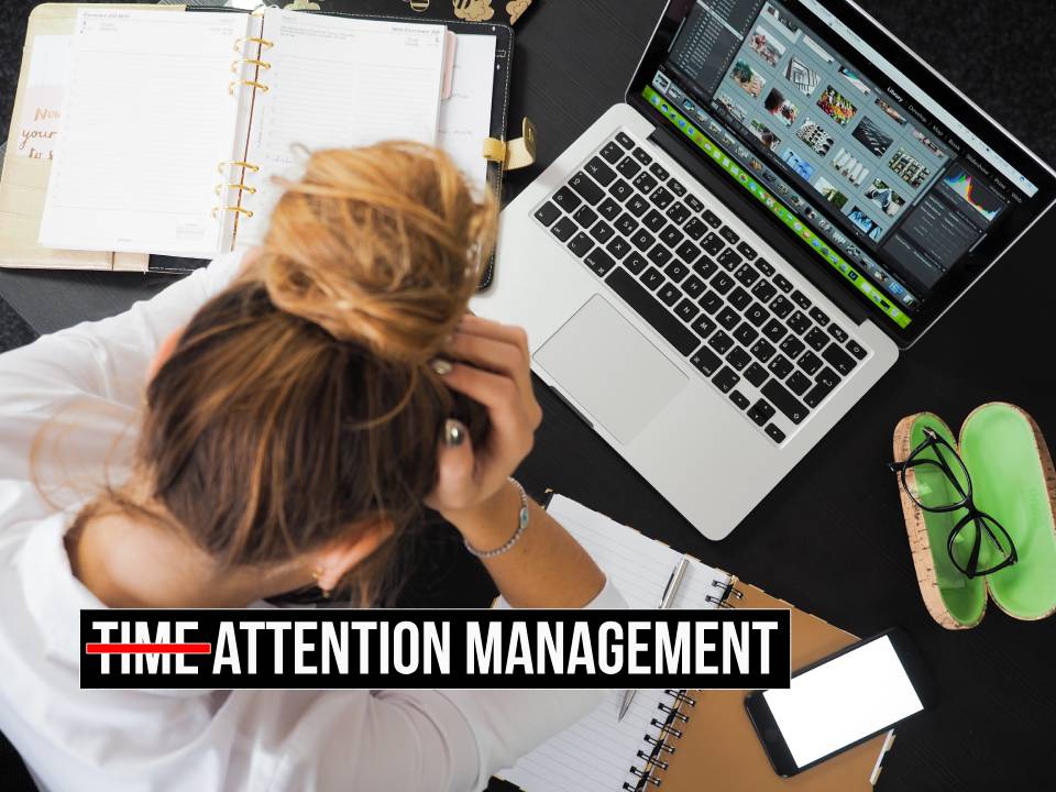 Stressed woman sitting at a desk with a computer, planner, and documents