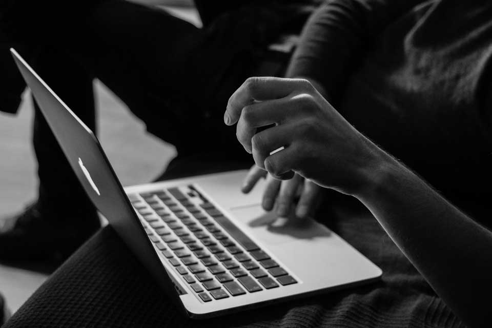 Person using a laptop computer, image in black & white