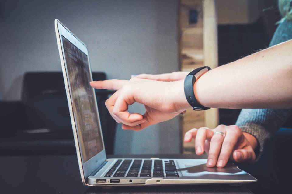 Working with an accountant, either together like these two people pointing at a computer, or virtually is easy with Debitoor invoicing & accounting software